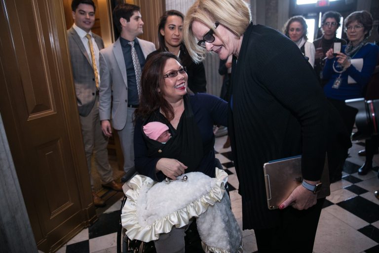 Sen. Tammy Duckworth, D-Ill., holds her newborn daughter, Maile Pearl Bowlsbey. On the right side of the picture, Sen. Claire McCaskill, D-Mo., looks on.