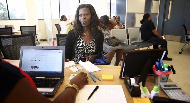 A woman works with a counselor at Miami's Borinquen Health Center to sign up for health coverage on Dec. 2. (AP Photo/J Pat Carter)