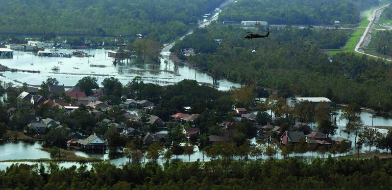 In this aerial photo, a Louisiana National Guard helicopter carries a sandbag to drop in an unintentional levee breach as it flies over the floodwaters in the aftermath of Hurricane Isaac in Braithwaite, La., Wednesday, Sept. 5, 2012. Thousands of electric customers are still without power, hundreds remained in shelters and several miles of coast line was tarred with weathered oil washing ashore, days after Isaac raked Louisiana. (AP Photo/Gerald Herbert)