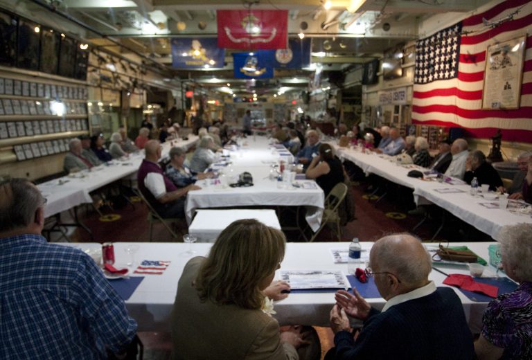 Holly Hughes, bottom center, state representative of the 91st district, speaks with Richard Hansen, right, a World War II veteran who served on USS LST 1046, during dinner at the Michigan LST Association reunion on September 21, 2011.  Hansen is the treasurer of the group.  The event was held for the last time on USS LST 393, which is one of two USS LST ships remaining. (AP Photo/Muskegon Chronicle, Greg Lindstrom)