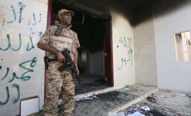 This Sept, 14, 2012 file photo shows a Libyan military guard standing in front of one of the U.S. Consulate's burnt-out buildings.ÃÂ Blue Mountain Group, the British company providing security at the U.S. compound in Benghazi during the Sept. 11, 2012, attack there, was hired by the State Department despite having lost several other contracts in Libya, according to emails obtained by watchdog group Judicial Watch.ÃÂ (AP Photo/Mohammad Hannon, File)