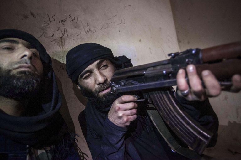   In this Wednesday, Dec. 5, 2012 photo, a Free Syrian Army fighter aims his weapon during heavy clashes with government forces in Aleppo, Syria. (AP Photo/Narciso Contreras)  