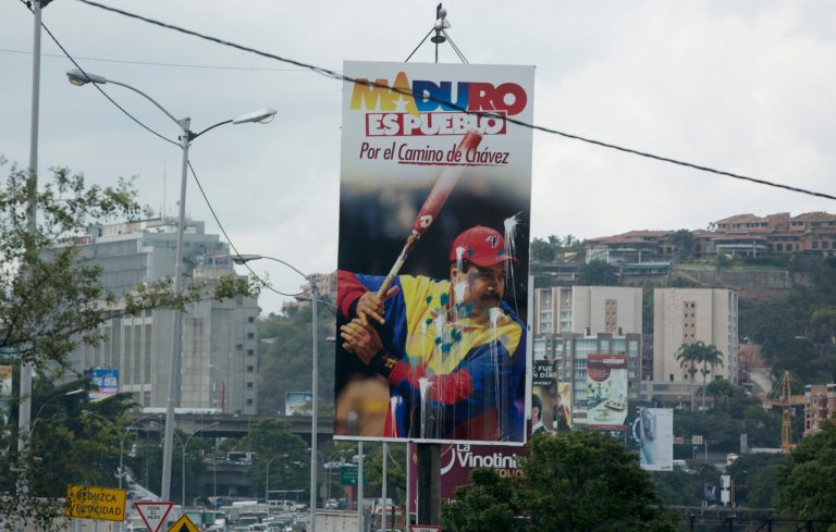 In this  July 15, 2014, photo, a defaced billboard promoting Venezuela's President Nicolas Maduro with a message that reads in Spanish; 