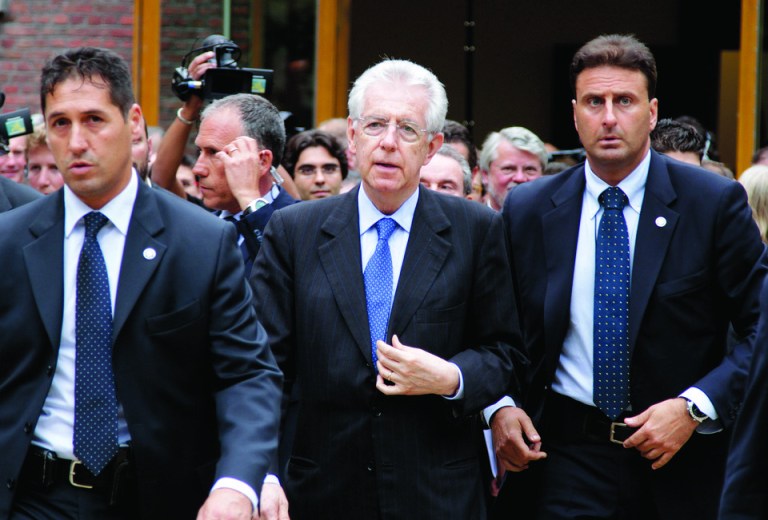 Italian Prime Minister Mario Monti, center, walks with bodyguards as he arrives for a meeting at the Bavarian Representation in Brussels on Wednesday, June 27, 2012. EU leaders will meet for a crucial EU Summit, beginning on Thursday, amid growing concerns over the financial health of Greece, Spain and Italy. (AP Photo/Virginia Mayo)