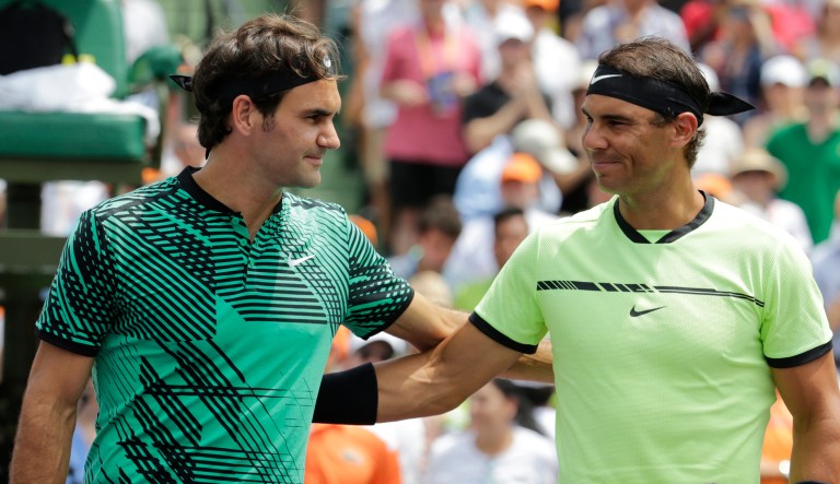 Roger Federer, and Rafael Nadal pose at the net before a tennis tournament. (AP Photo/Lynne Sladky)