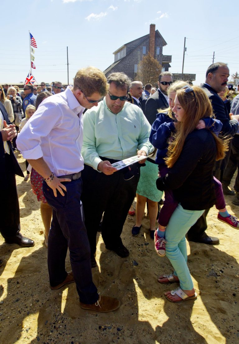 Britain's Prince Harry and N.J. Gov. Chris Christie look at a before photo of a home that belongs to the Bowden family home which is now empty lot in Mantoloking, N.J. on Tuesday, May 14, 2013. Prince Harry began a tour Tuesday of New Jersey's storm-damaged coastline, inspecting dune construction, walking past destroyed homes and shaking hands with police and other emergency workers. (AP Photo/The Star-Ledger, Andrew Mills, Pool)