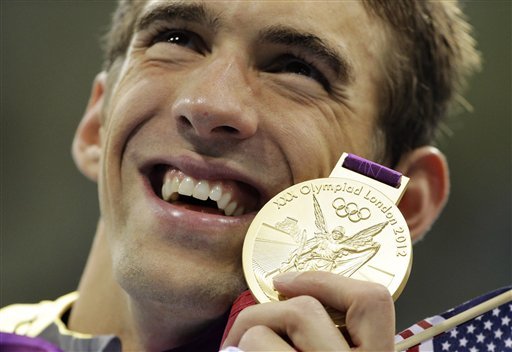 United States' Michael Phelps poses with his gold medal for the men's 4x200-meter freestyle relay swimming final at the Aquatics Centre in the Olympic Park during the 2012 Summer Olympics in London, Tuesday, July 31, 2012. (AP Photo/Matt Slocum)