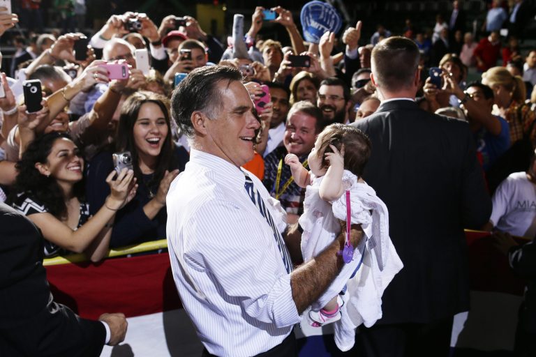 Republican presidential candidate, former Massachusetts Gov. Mitt Romney picks up a baby from the audience as he campaigns at the Bank United Center, at The University of Miami, in Coral Gables, Florida, Wednesday, Oct. 31, 2012. (AP Photo/Charles Dharapak)