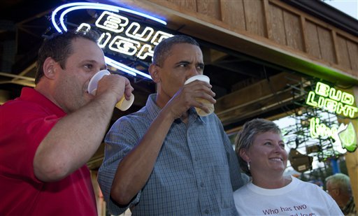 President Barack Obama has a beer with Mike Cunningham III, left, and another worker at the beer stand during a visit to the Iowa State Fair, Monday, Aug. 13, 2012, in Des Moines, Iowa. The president is on a three-day campaign bus tour through Iowa. (AP Photo/Carolyn Kaster)