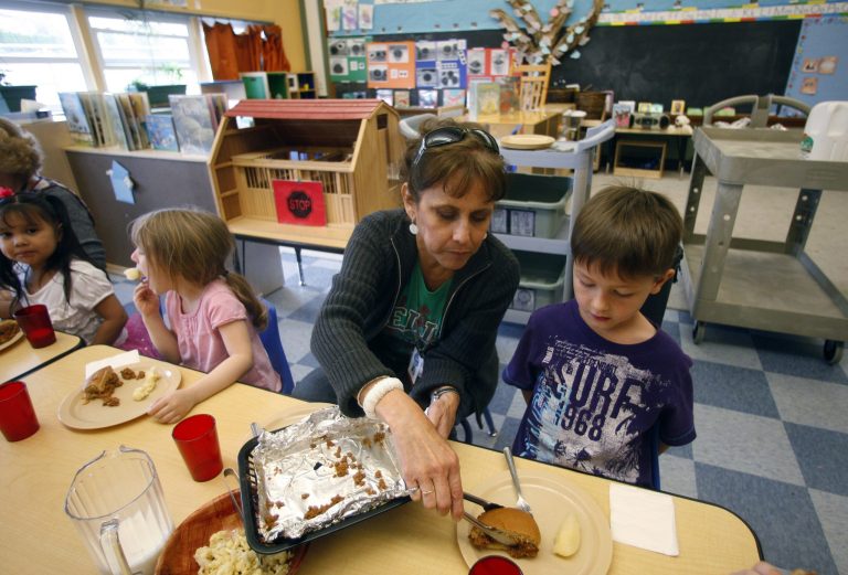 Teacher Diana Feke helps Mason Baker, 5, during lunch at the Eastham Community Center Claskamas County Children's Commission Head Start Monday, April 9, 2012, in Oregon City, Ore. (AP/Rick Bowmer)