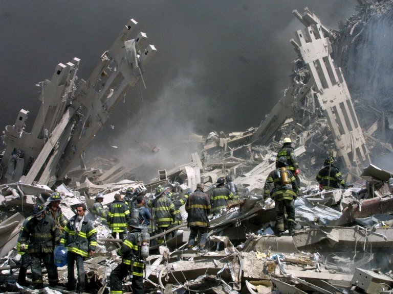 In this Sept. 11, 2001 file photo, firefighters make their way through the rubble after two airliners crashed into the World Trade Center in New York bringing down the landmark buildings. The White House lashed out at Congress on Thursday, Sept. 29, 2016, a day after Republicans and Democrats overwhelmingly overrode President Barack Obama's veto of a bill to allow families of the 9/11 victims to sue Saudi Arabia. The White House turned to mockery as top GOP leaders expressed buyer's remorse and vowed to fix the bill. (AP Photo/Shawn Baldwin)