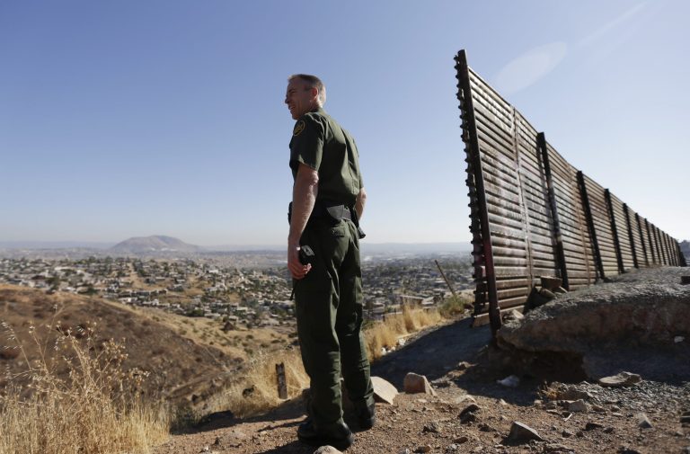 In this June 13, 2013, file photo, Border Patrol agent Jerry Conlin looks out over Tijuana, Mexico, along the old border wall along the U.S.-Mexico border.