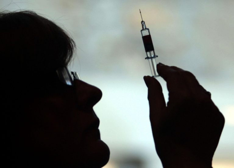 A nurse prepares to give a patient a shot from a hypodermic needle. David Cheskin/PA Wire (Press Association via AP Images)