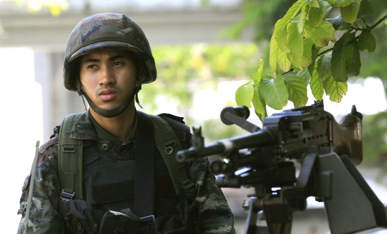 A Thai soldier stands guard outside the Thai police headquarters Tuesday, May 20, 2014, in Bangkok, Thailand. Thailand's army declared martial law before dawn Tuesday in a surprise announcement it said was aimed at keeping the country stable after six months of sometimes violent political unrest. The military, however, denied a coup d'etat was underway.  (AP Photo/Sakchai Lalit)
