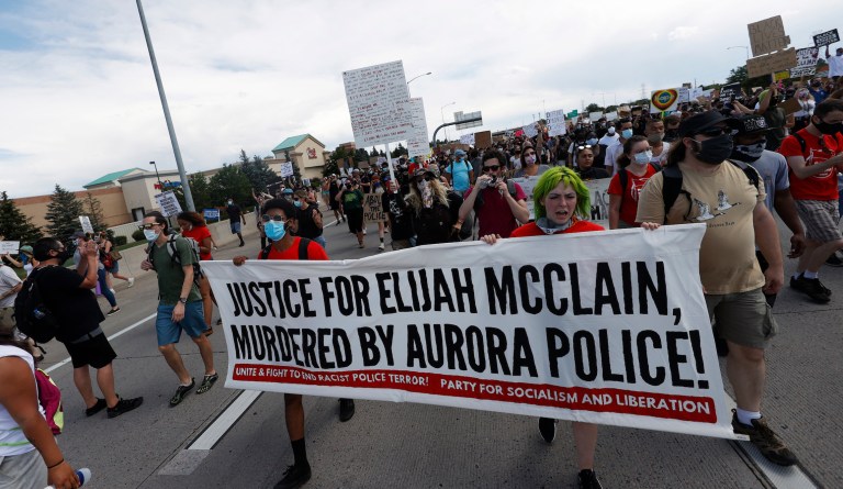 Demonstrators move along Interstate 225 after closing down the highway during a rally and march over the death of 23-year-old Elijah McClain Saturday, June 27, 2020, in Aurora, Colo. McClain died in late August 2019 after he was stopped while walking to his apartment by three Aurora Police Department officers. (AP Photo/David Zalubowski)