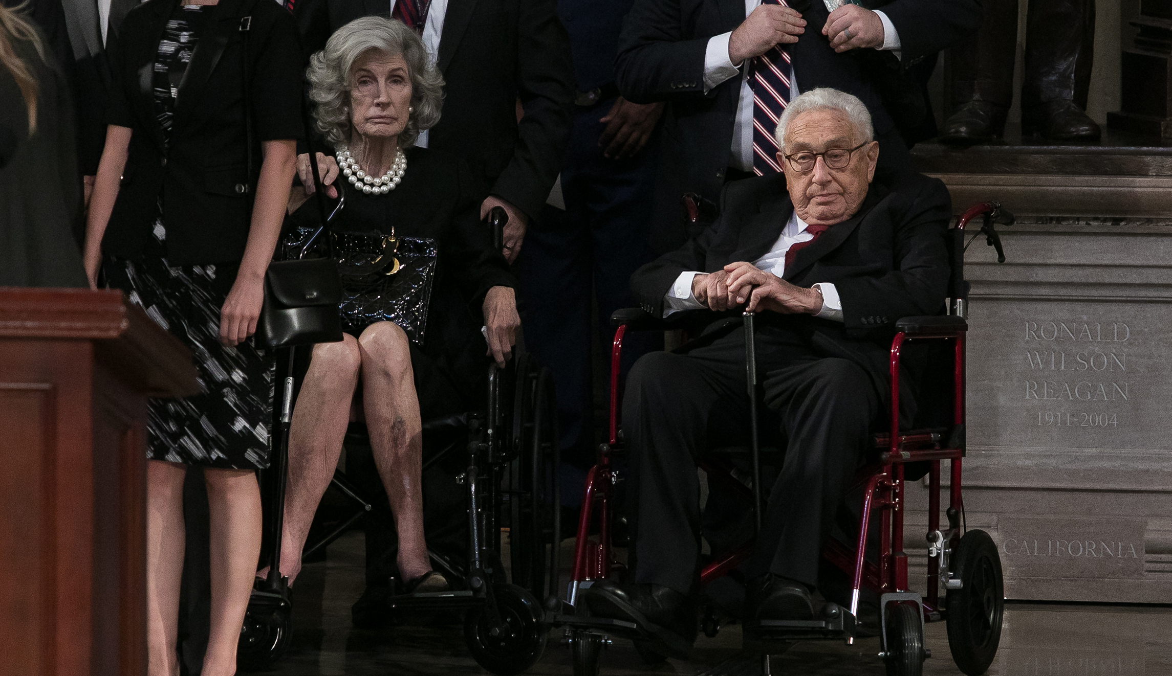 Former Secretary of State Henry Kissinger (pictured right) sits among other onlookers as Sen. John McCain's casket is placed inside the Capitol Rotunda in Washington, D.C.