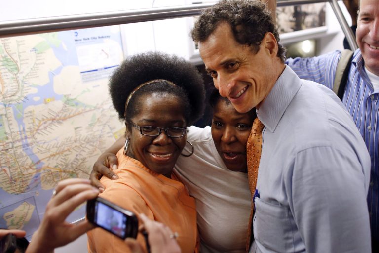 New York City mayoral hopeful Anthony Weiner poses for a photo with straphangers as he rides the subway to a radio appearance on the first day of his campaign, Thursday, May 23, 2013 in New York. Weiner, who ran for mayor in 2005 and nearly did in 2009, is getting into the race to succeed three-term Mayor Michael Bloomberg about two years after a series of tawdry tweets, and obfuscating explanations that capsized his promising congressional career. (AP Photo/Jason DeCrow)