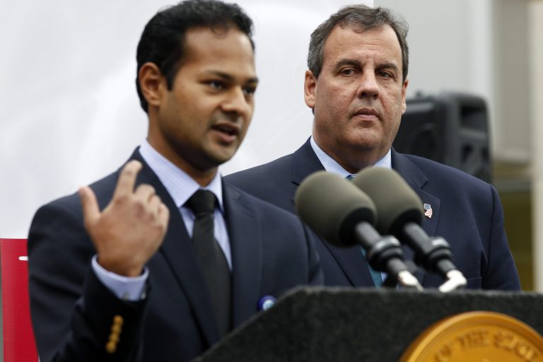 New Jersey Gov. Chris Christie, right, looks on as Dr. Soumen Samaddar addresses a gathering of medical professionals and media at the Bristol-Myers Squibb Children's Hospital at Robert Wood Johnson University Hospital, after Christie announced a new partnership aimed at combating prescription drug abuse Tuesday, Oct. 7, 2014, in New Brunswick, N.J. (AP Photo/Mel Evans)