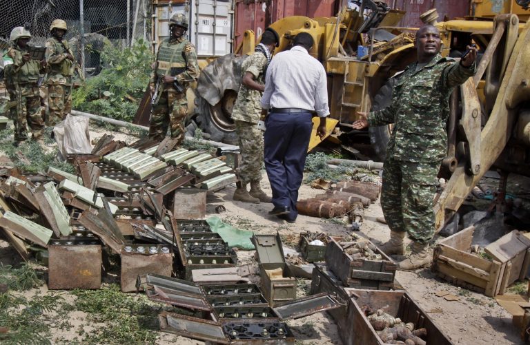 In this photo taken Sunday, July 27, 2014, African Union (AU) peacekeepers stand near a cache of weapons recovered from a garage in Mogadishu, Somalia. An official says that Somalia's government has launched a new disarmament campaign, that has netted some 500 guns during four raids, which is being carried out because officials fear that weapons could fall into the hands of al-Qaeda-linked fighters. (AP Photo/Farah Abdi Warsameh)