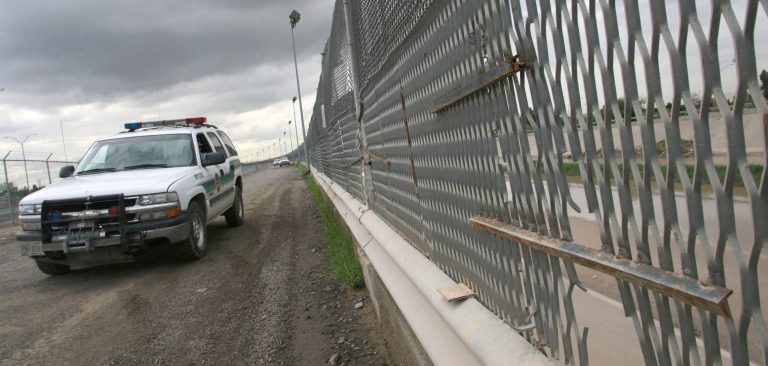 A Border Patrol vehicle drives past a portion of the border fence that has had a hole cut out of it in El Paso, Texas. (AP/Victor Calzada)