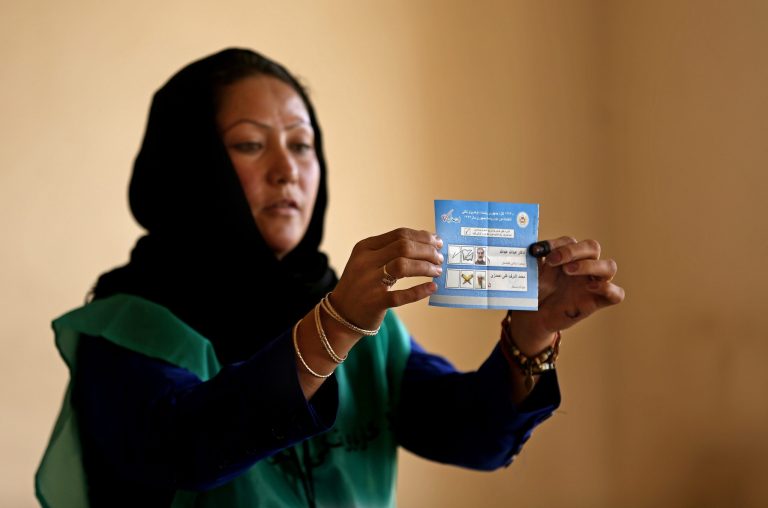 An Independent Election Commission (IEC) employee shows a ballot to observers at a polling station in Kabul, Afghanistan, Saturday, June 14, 2014. Despite a Taliban threat to stay away, Afghans lined up Saturday to vote in a presidential runoff between two candidates who both promise to improve ties with the West and combat corruption as they confront a powerful Taliban insurgency and preside over the withdrawal of most foreign troops by the end of the year. (AP Photo/Massoud Hossaini)