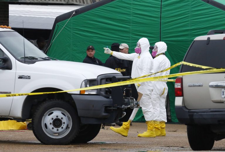 Federal authorities in hazmat suits stand outside a small retail space where neighboring business owners said Everett Dutschke used to operate a martial arts studio, Wednesday, April 24, 2013 in Tupelo, Miss., in connection with the recent ricin attacks. No charges have been filed against Dutschke and he hasn't been arrested. (AP Photo/Rogelio V. Solis)