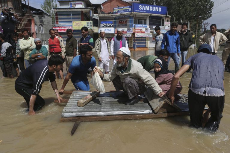 Kashmiri men use a makeshift raft to evacuate an elderly man and his grand daughter from a flooded neighborhood in Srinagar, India, Sunday, Sept.7, 2014. Fast-moving floodwaters submerged large parts of the main city in Indian-controlled Kashmir on Sunday after five days of pounding rain. The flooding, the worst in 50 years, has killed at least 120 people across the Himalayan region.(AP Photo/Dar Yasin)