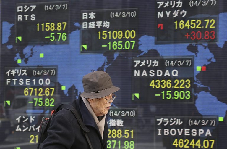 A man walks past a world stock price chart on a street in Tokyo, Monday, March 10, 2014. Asian stock markets sank Monday, battered by weak Chinese trade and a reduced estimate for Japan's economic growth. Shares in Malaysia Airlines tumbled on news of the weekend disappearance of one its jets enroute to Beijing. Japan's Nikkei 225 fell 1.1 percent to 15,111.92. (AP Photo/Eugene Hoshiko)