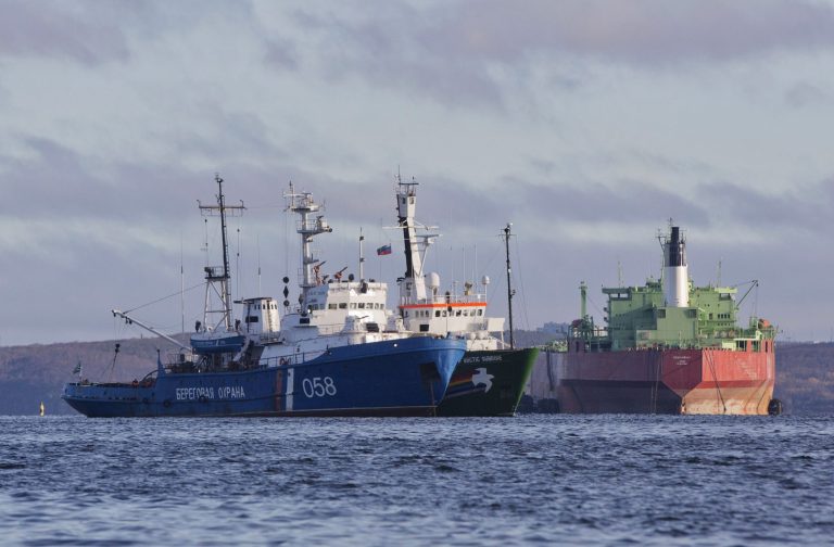 The Greenpeace ship Arctic Sunrise, center, is anchored side by side with a Russian Coast Guard Ship, left, in the Kolskii gulf, near Murmansk, Russia. Russian investigators say they're considering fresh charges against Greenpeace activists who were detained last month for an Arctic protest. 29 Greenpeace activists and a freelance Russian journalist have been charged with piracy after their September protest at an oil platform in the Arctic. (AP Photo/ Evgeny Feldman)