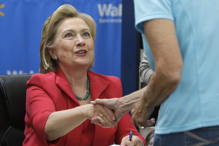Former Secretary of State Hillary Clinton greets customers at a Little Rock, Ark., Wal-Mart store as she signs copies of her book 