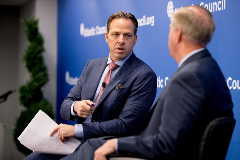 CNN journalist Jake Tapper, left, speaks with Republican presidential candidate Sen. Lindsey Graham, R-S.C., right, on stage during the Atlantic Council's series 