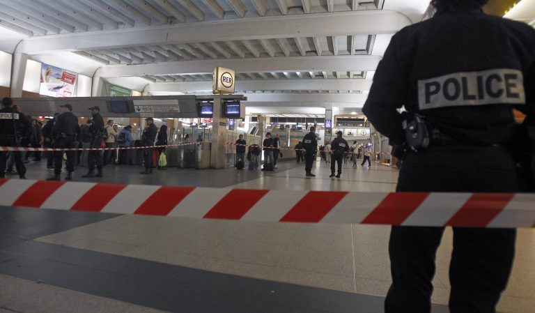 Police officers stand near the cordoned off spot where a French soldier was stabbed in the throat in the busy commercial district of La Defense, outside Paris, Saturday May 25, 2013, and France's president said authorities are investigating any possible links with the recent slaying of a British soldier.(AP Photo/Remy de la Mauviniere)