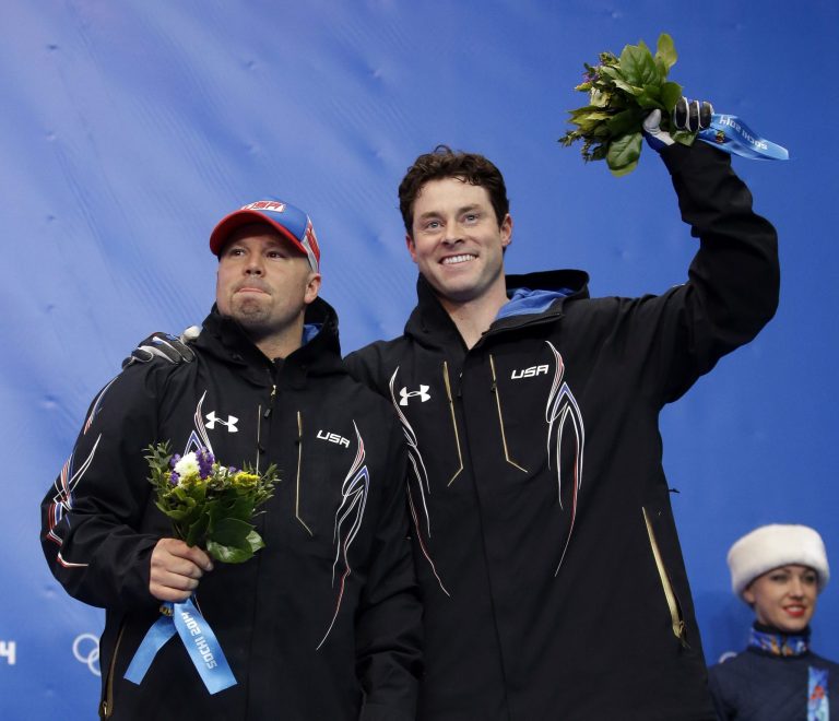 The team from the United States USA-1, piloted by Steven Holcomb and brakeman Steven Langton, celebrate their bronze medal win after the men's two-man bobsled competition at the 2014 Winter Olympics, Monday, Feb. 17, 2014, in Krasnaya Polyana, Russia. (AP Photo/Dita Alangkara)
