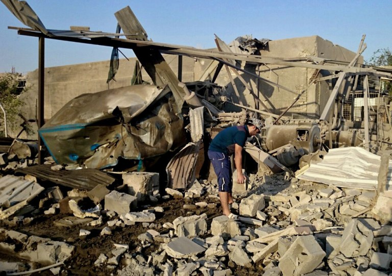 In this Tuesday, July 29, 2014 photo, a generator owner inspects his community generator that was destroyed after a bombing in Fallujah, 40 miles (65 kilometers) west of Baghdad, Iraq. Last month's rapid advance of the Islamic State group, which captured Iraq's second largest city of Mosul, has plunged the country into its worst crisis since the withdrawal of U.S. troops in 2011 with more than a million Iraqis now classified as internally displaced or refugees. (AP Photo)