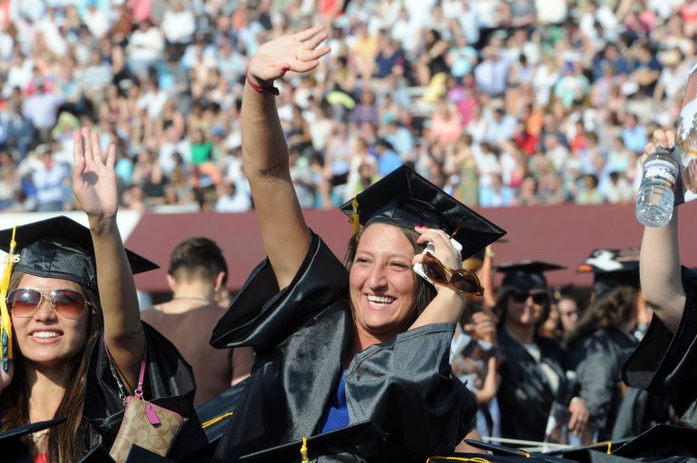 Students wave during graduation ceremonies for the University of Massachusetts Amherst at McGuirk Stadium on campus in Amherst, Mass. on Friday, May 8, 2015. (Don Treeger/The Republican via AP)