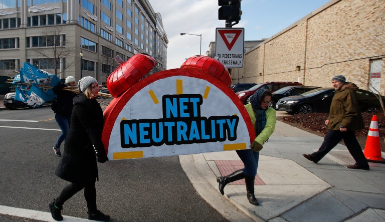 Sammi LeMaster, left, and Katherine Fuchs, right, carry the top of an alarm clock display that reads "Net Neutrality" down 12th Street SW to their truck after a protest at the Federal Communications Commission (FCC) in Washington, Thursday, Dec. 14, 2017, where the FCC is scheduled to meet and vote on net neutrality. The vote scheduled today, Thursday, Dec. 14, 2017, at the FCC could usher in big changes in how Americans use the internet, a radical departure from more than a decade of federal oversight.
