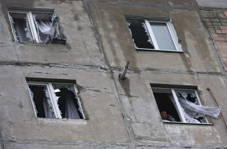 A man speaks phone near a broken window in his house after shelling in Luhansk, eastern Ukraine Tuesday, July 8, 2014. Local residents said it was a shelling from the Ukrainian army's side. The Ukrainian government will restart cease-fire negotiations with pro-Russian insurgents in the country's east only once the rebels lay down their weapons, the defense minister said Tuesday. (AP Photo/Dmitry Lovetsky)
