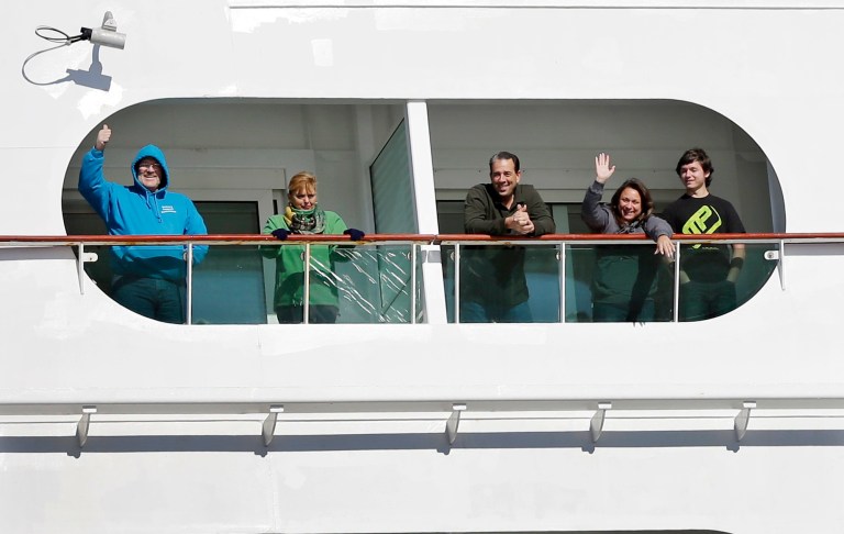 Passengers wave from the Explorer of the Seas cruise ship as it docks at a berth in Bayonne, N.J., Wednesday, Jan. 29, 2014. The number of passengers and crew reported stricken ill on the cruise ship has risen to nearly 700. The U.S. Centers for Disease Control and Prevention said Wednesday its latest count puts the number of those sickened aboard the Explorer of the Seas at 630 passengers and 54 crew members. (AP Photo/Mel Evans)