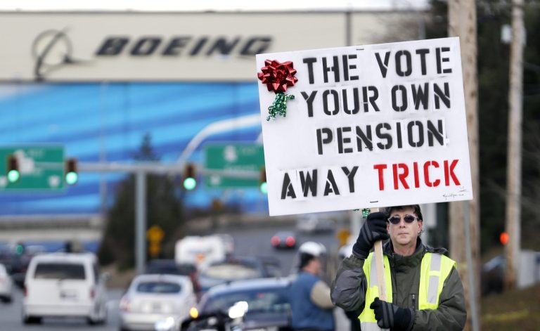 Boeing machinists union member Kevin Flynn walks near a union hall in support of his leaders' rejection of Boeing's last contract offer as he waits for a small group of protesters who instead favor a vote, Wednesday, Dec. 18, 2013, in Everett, Wash. Local union leaders rejected the offer last week because they said it was too similar to one voted down last month, but the national union has set a vote date of Jan. 3. (AP Photo/Elaine Thompson)