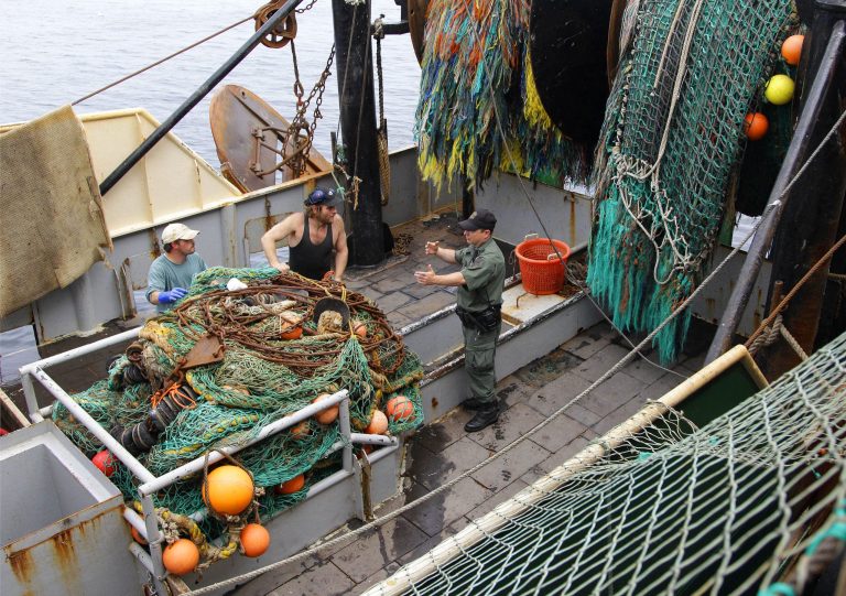   FILE - This May 14, 2012 file photo shows a Massachusetts Environmental Agency enforcement officer talking to members of the crew on the fishing vessel Green Acres in New Bedford, Mass. Federal efforts to rebuild depleted fish populations have largely been successful, but pressure to overfish some species remains high and some fish stocks have not rebounded as quickly as projected, a new report says The report comes from the National Research Council, an arm of the National Academies of Science. It says 43 percent of fish stocks identified as being overfished were rebuilt or showed good progress toward rebuilding within 10 years. Another 31 percent were on track to rebuild if sharply reduced fishing levels remain in place. But the report also says 26 percent of overfished stocks continue to be overfished. (AP Photo/Stephan Savoia, File)  