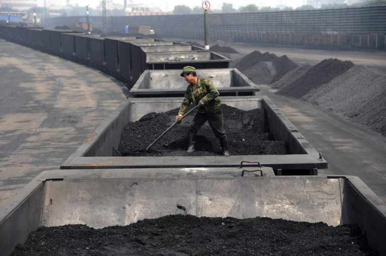 FILE - In this Wednesday, July 31, 2013, file photo, a worker levels the coal on a freight train in Taiyuan in northern China's Shanxi province. Coal has been the dominant fuel for power generation for a century because it is cheap, plentiful, and easy to ship and store. But it emits a host of pollution-forming gases and soot particles, and double the greenhouse gas emissions of its closest fossil fuel competitor, natural gas. (AP Photo/File) CHINA OUT