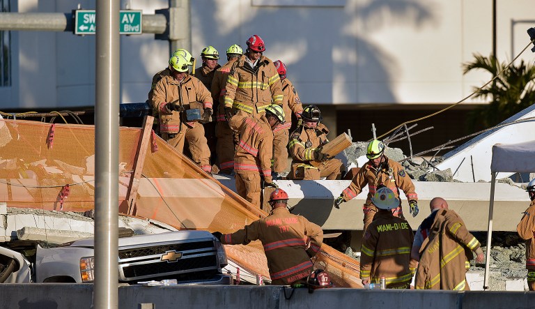 Miami-Dade Fire Rescue firefighters work on a brand new, 950-ton pedestrian bridge that collapsed in front of Florida International University, Thursday, March 15, 2018, in Miami. Florida officials said Thursday that several people have been found dead in the rubble of a collapsed South Florida pedestrian bridge where the frantic search for any survivors continued past nightfall.