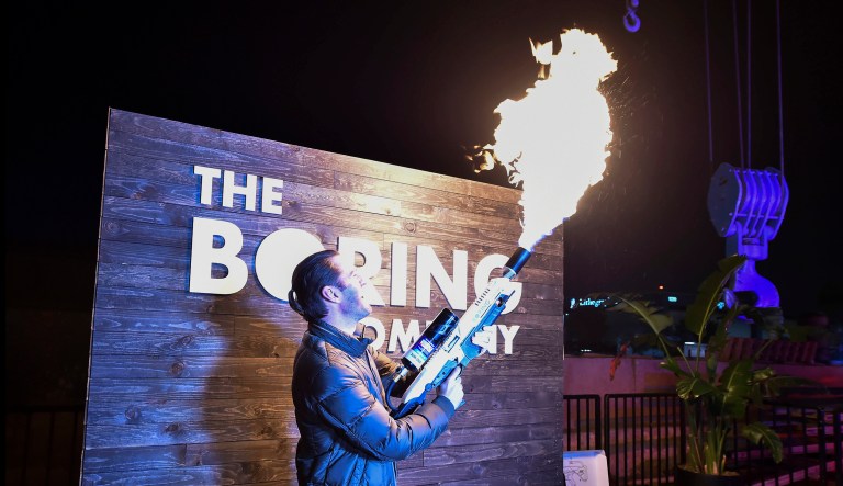 An attendee operates a Boring Company flamethrower at the company's photo booth during an unveiling event for the Boring Co.