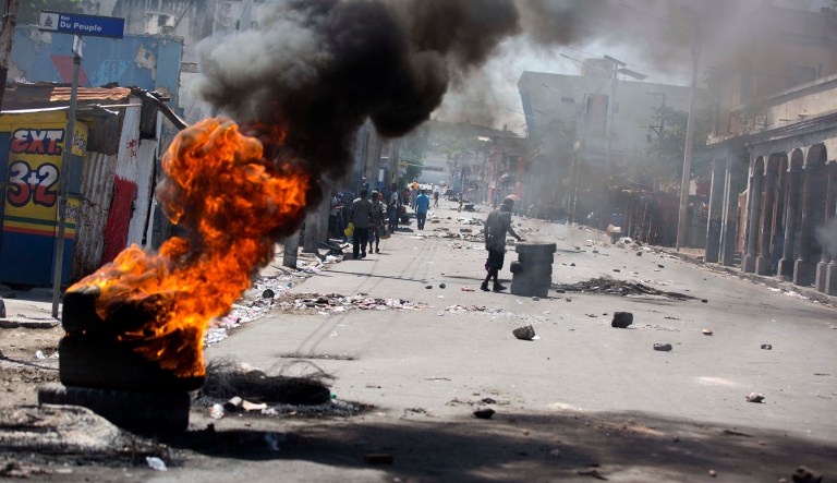Tires burn at a road block set up by anti-government protesters downtown during a general strike in Port-au-Prince, Haiti, early Monday, July 9, 2018. A nationwide, general strike and protest was called to demand the resignation of Haiti's President Jovenel Moise after his government agreed to reduce subsidies for fuel as part of an assistance package with the International Monetary Fund. The fuel hike was suspended after widespread, violent protests broke out on Friday and over the weekend.