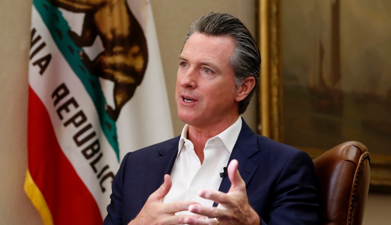 California Gov. Gavin Newsom, left, flanked by Attorney General Xavier Becerra, right, answers a question concerning a  lawsuit the state will likely file against President Donald Trump over his emergency declaration to fund a wall on the U.S.-Mexico border Friday, Feb. 15, 2019, in Sacramento, Calif.
