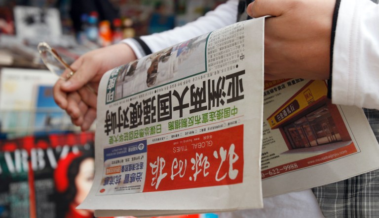 A Chinese man holds a copy of Global Times newspaper reporting tension facing between China and Japan after he bought it at a news stand in Beijing Tuesday, Sept. 21, 2010. Japan warned Tuesday against fanning "extreme nationalism" in a diplomatic standoff with China over the detention of a Chinese fishing captain after his boat collided with Japanese vessels near disputed islands.
