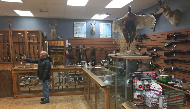 Postal Service worker Gene Rodriguez, 56, handles an unloaded firearm at The Outdoorsman gun shop in Santa Fe, N.M., on Thursday, Jan. 5, 2017.