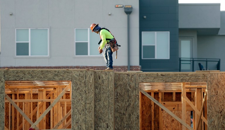 In this July 12, 2017 photo, a construction worker walks along the top of a residential complex in Nashville, Tenn.