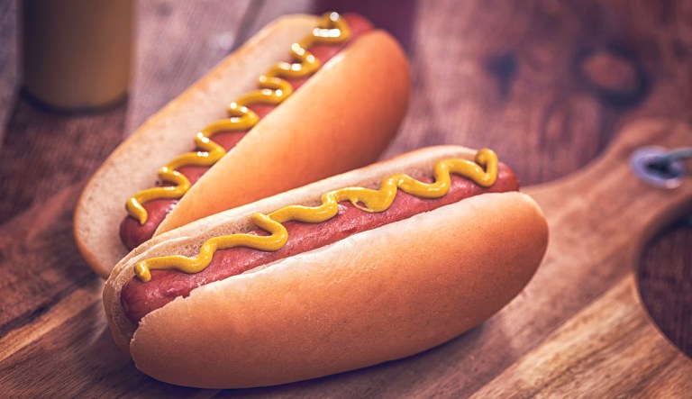 Preparing homemade hot dogs with mustard.