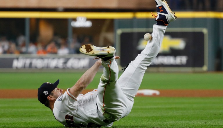 Houston Astros starting pitcher Justin Verlander tries to make a play on a ball hit by Washington Nationals' Ryan Zimmerman during the fourth inning of Game 2 of the baseball World Series Wednesday, Oct. 23, 2019, in Houston.
